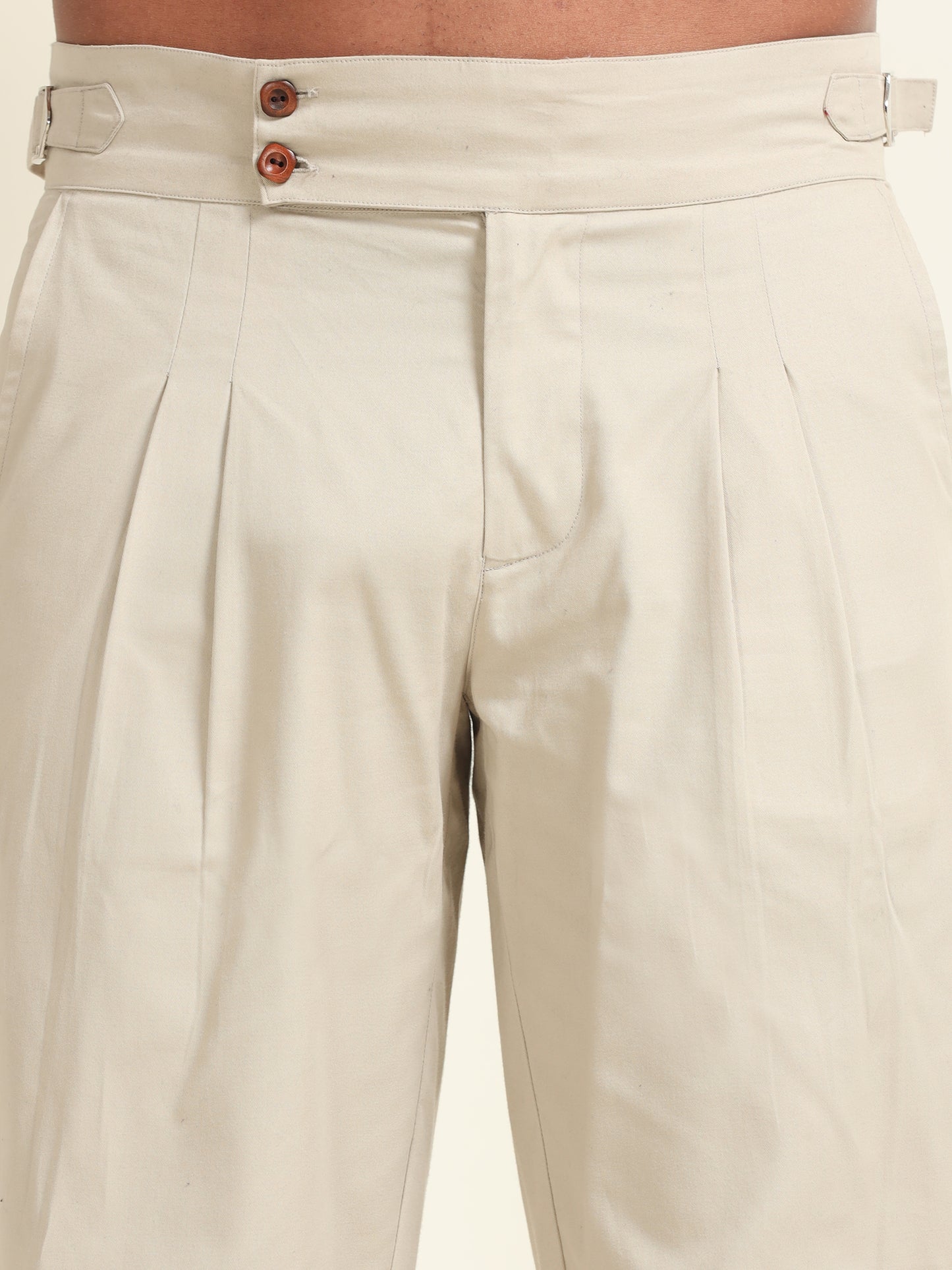 Model wearing beige double pleat straight fit pants, offering a polished look with tailored details and a perfect fit