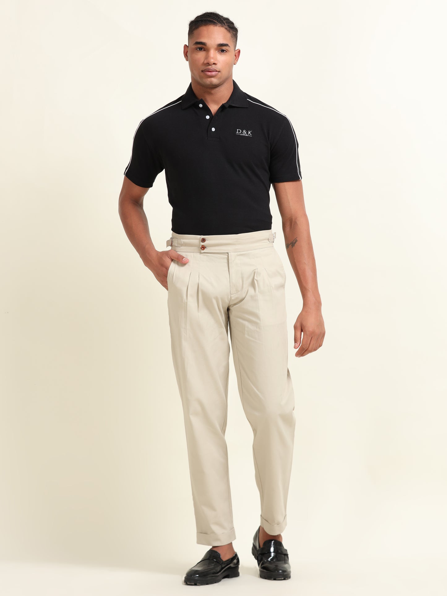 Close-up of side waist belts on beige double pleat straight fit pants, providing an adjustable and custom-tailored fit